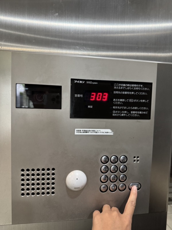 オートロックのインターホンで303を入力している様子